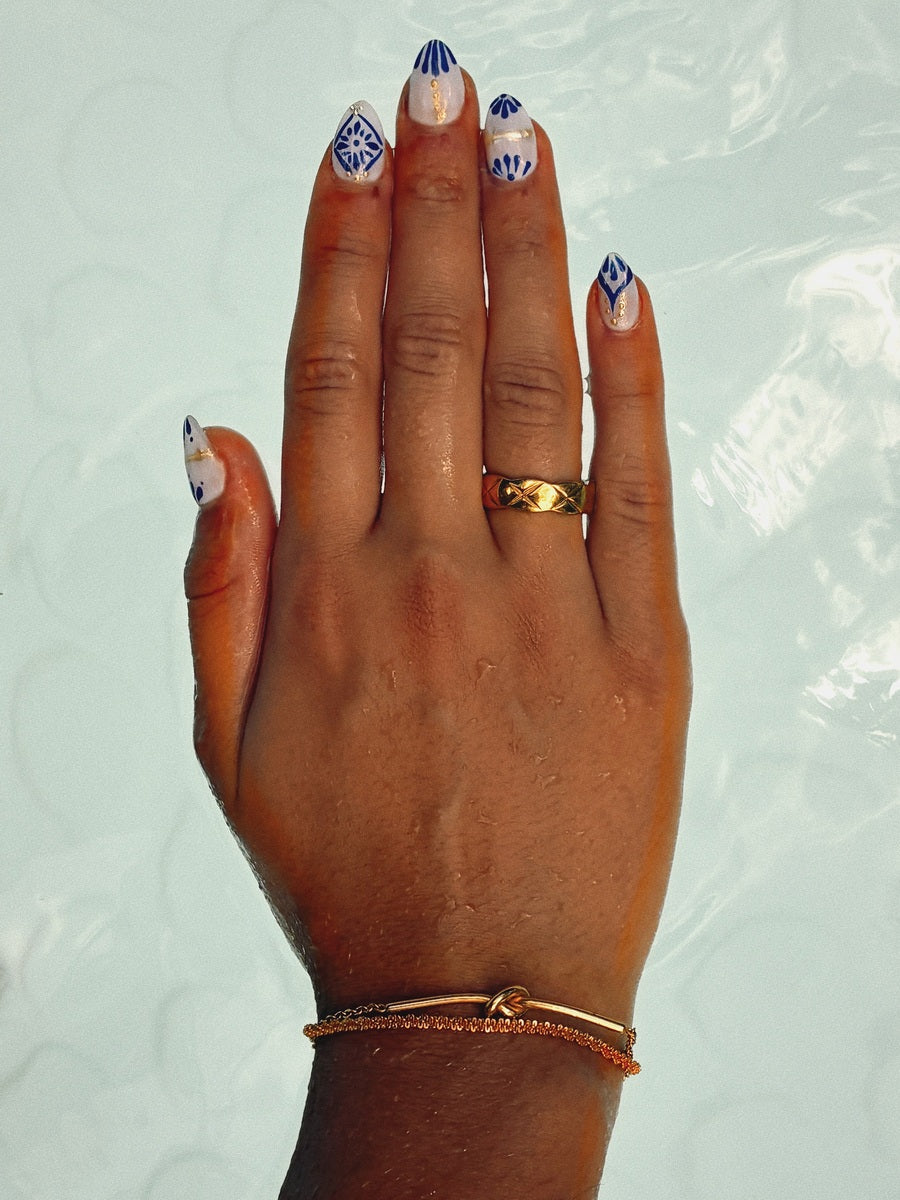 Maré gold jewellery on Portuguese-inspired blue tile